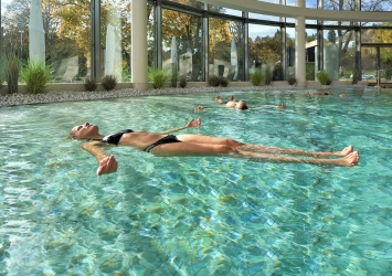 Eine Frau schwebt horizontal im Solebecken