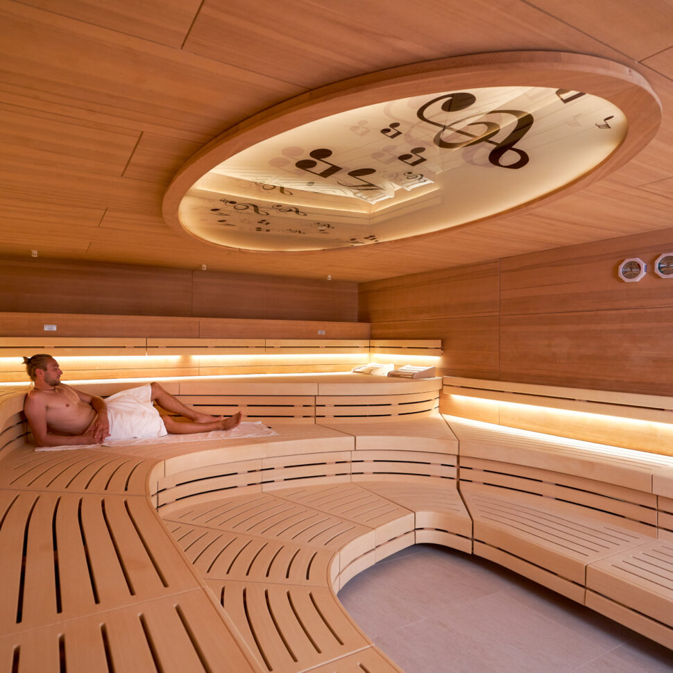 Ein Mann liegt auf den Arm gestützt in der Sauna