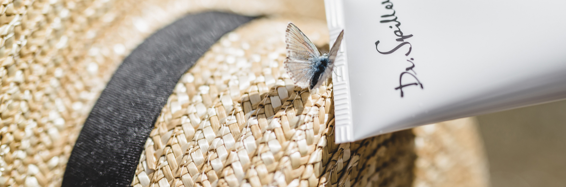Ein Strohhut mit Schmetterling und einer Dr. Spiller Tube
