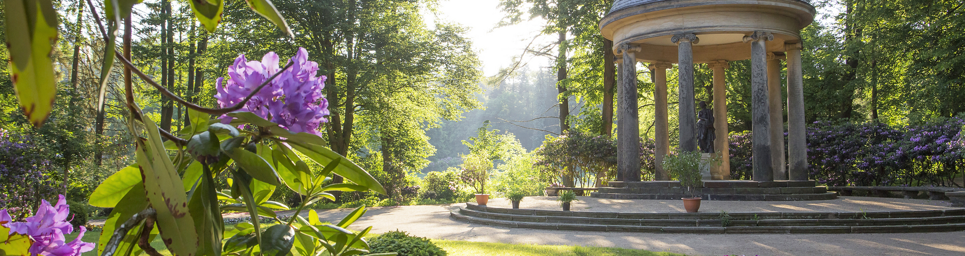 Floratempel umgeben von Wald und die Sonne scheint