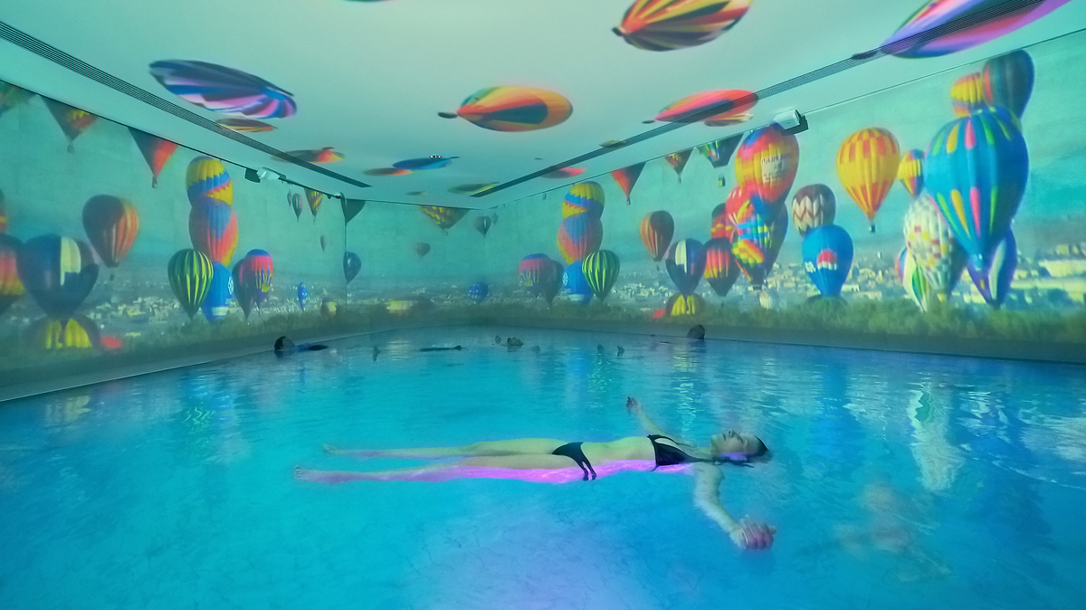 Eine Frau liegt horizontal schwebend im Sole-Therme-Becken