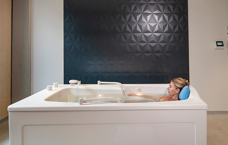 Eine Frau liegt in einer modernen Badewanne