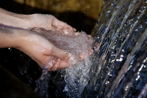 In Hände läuft Radon-Mineralheilwasser