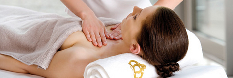 Eine Frau liegt mit dem Rücken auf einer Massageliege und bekommt eine Dekolleté Massage