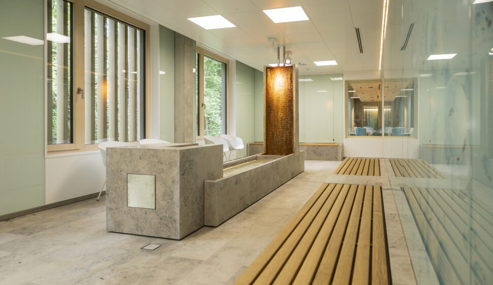 Radon-Inhalaltionsraum mit Holzbänken, grünlichem Glas und Marmorboden