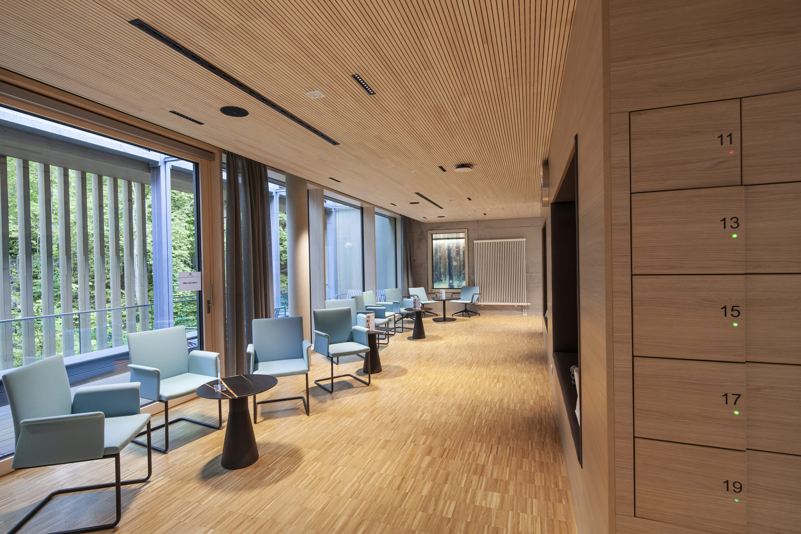 Wartebereich Radon-Therapiezentrum: Ein Raum in Holzverkleidung und mint-farbenen Stühlen