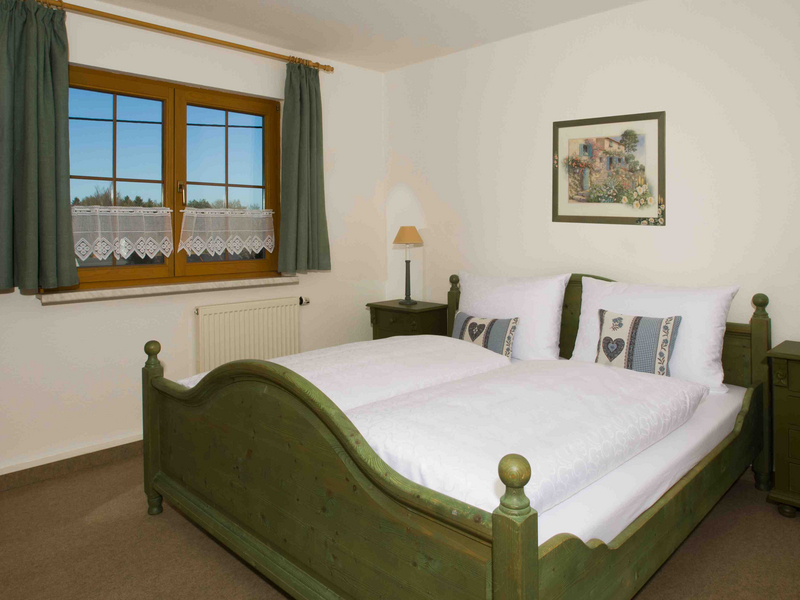 Blick auf ein Doppelbett aus Holz in grün