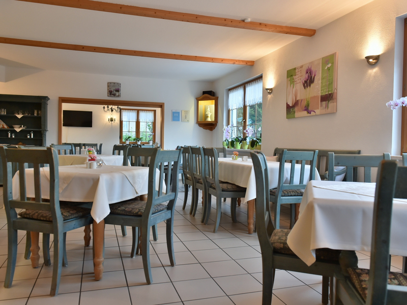 Landhotel Jungbrunnen Speiseraum mit weißen Tischdecken und Holz-grünen Stühlen
