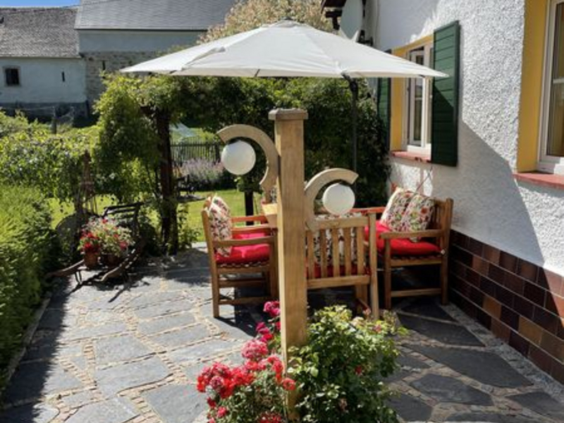 Außenbereich mit Sitzplatz und Sonnenschirm