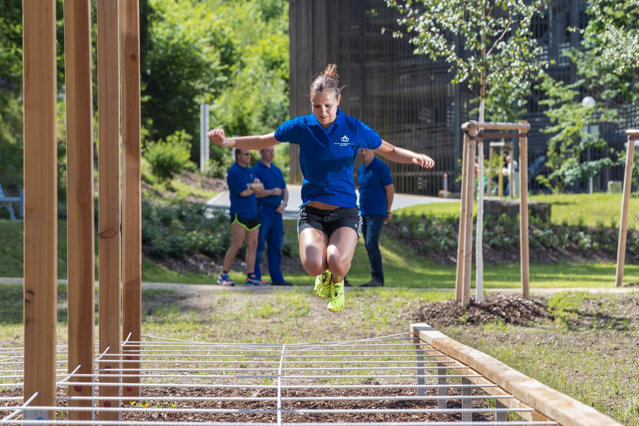 Eine Frau springt im Fitnesspark über Seile