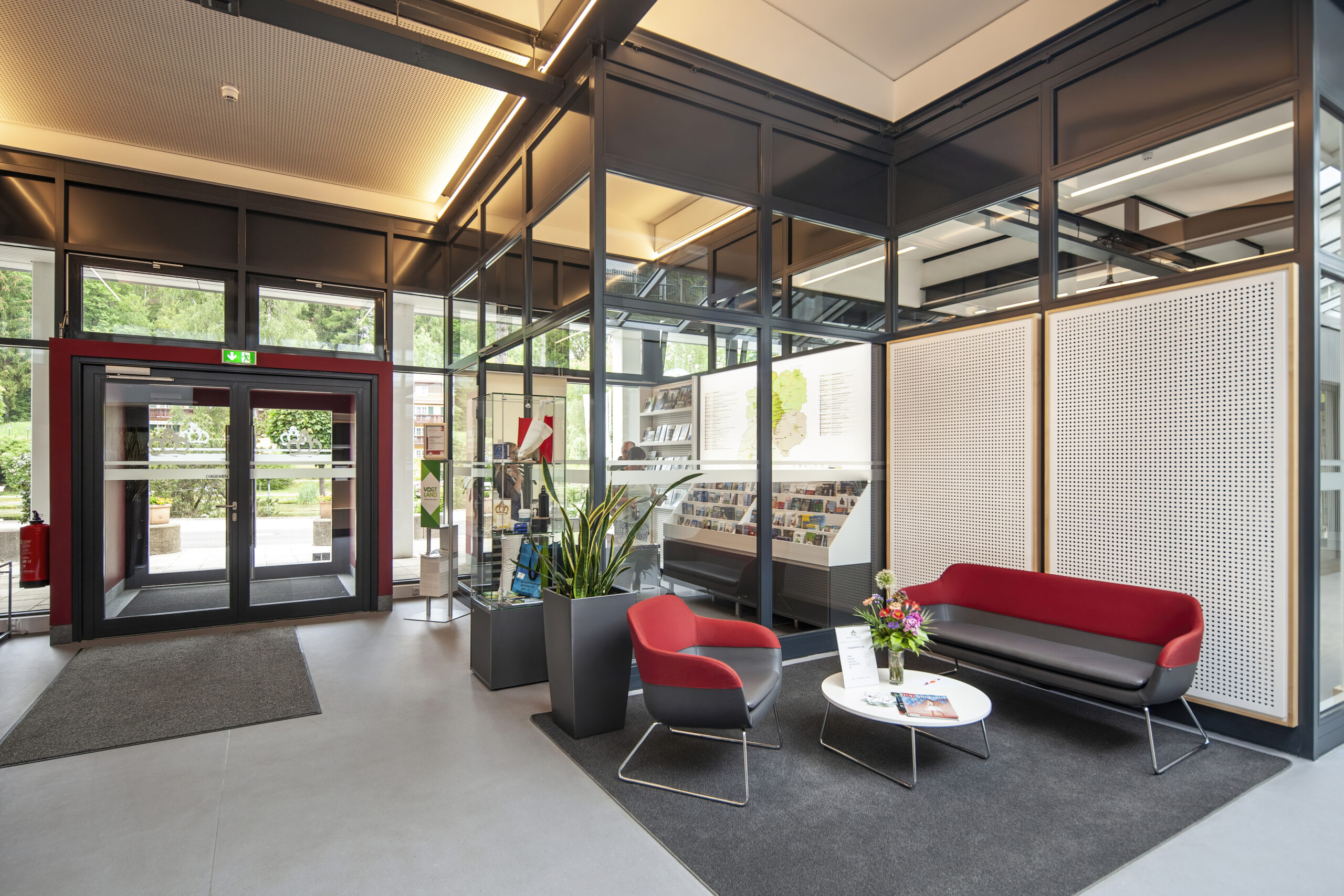 Innenansicht der Touristinformation eine in rot/grau gehaltene Sitzecke